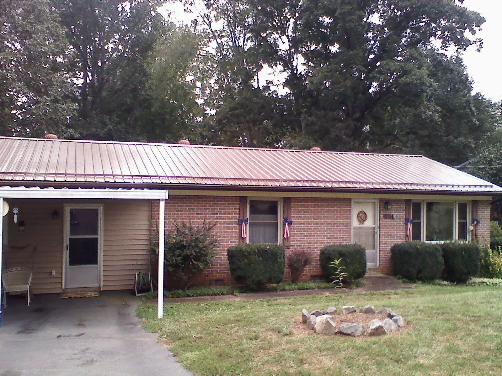 Bronze metal roof and carport on a brick ranch home — Roof Repair work by our crew in Poplar Branch